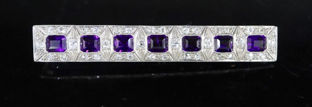 An early to mid 20th century 18ct white gold, amethyst and diamond cluster set bar brooch,